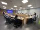 A imagem mostra várias pessoas sentadas à mesa em uma sala, numa reunião de diretores logistas e empresários